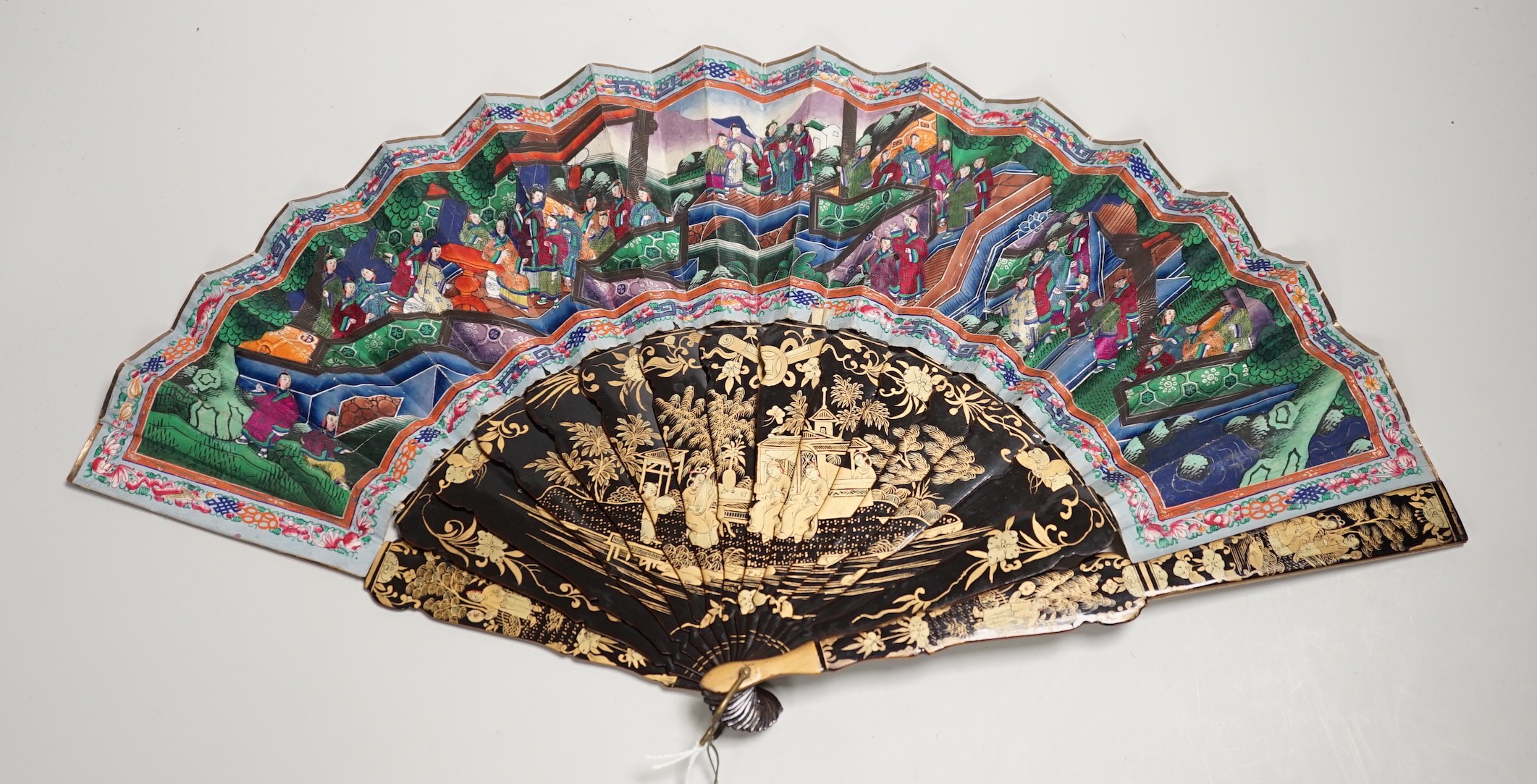 A 19th century Chinese painted paper leaf and lacquer painted fan in a gilt decorated black lacquer fitted case, the fan with painted ivory appliqué faces, 28cm